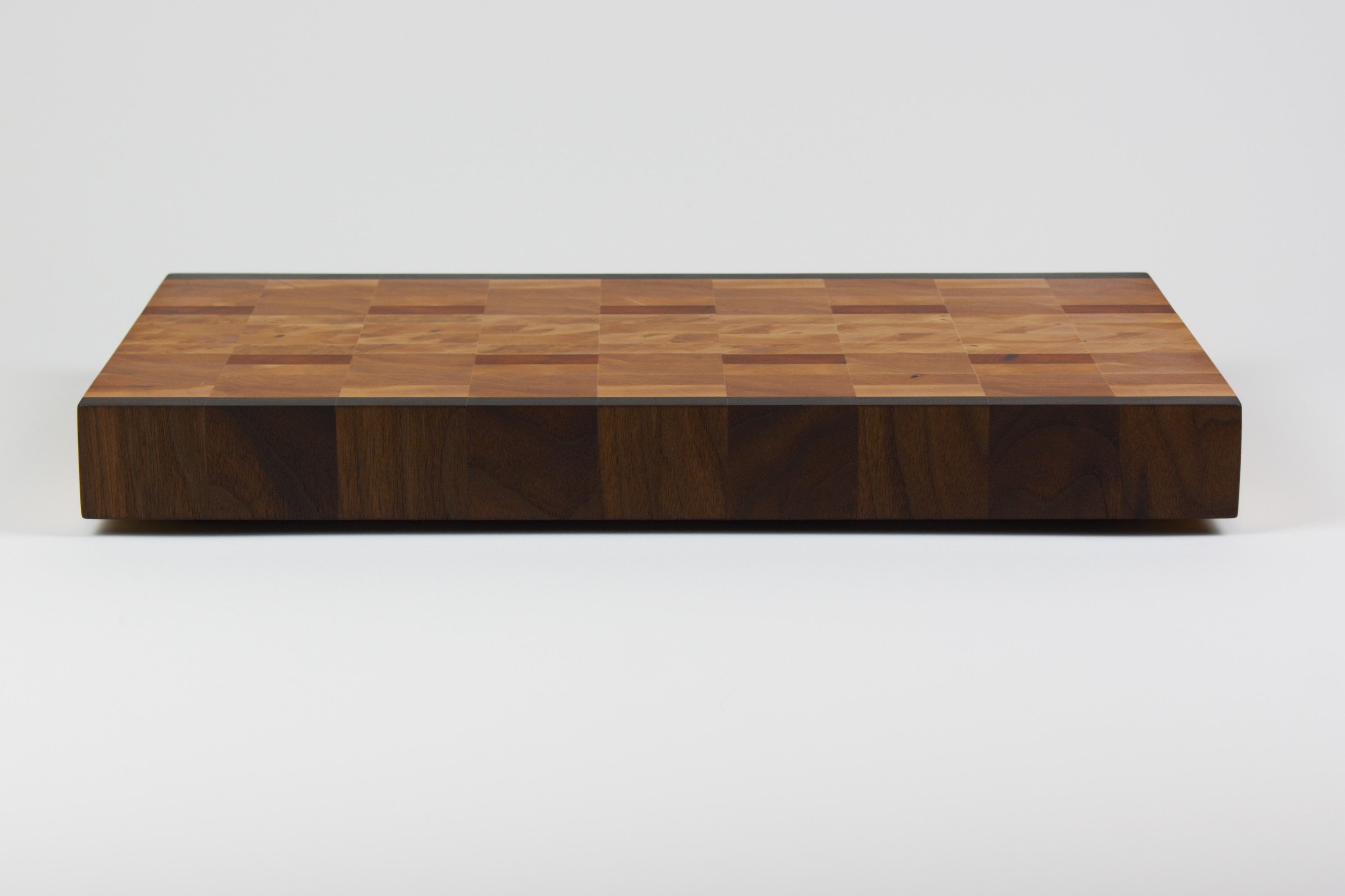 End grain cutting board made of rustic Hard Maple and accented with Tigerwood and Black Walnut, rear view.