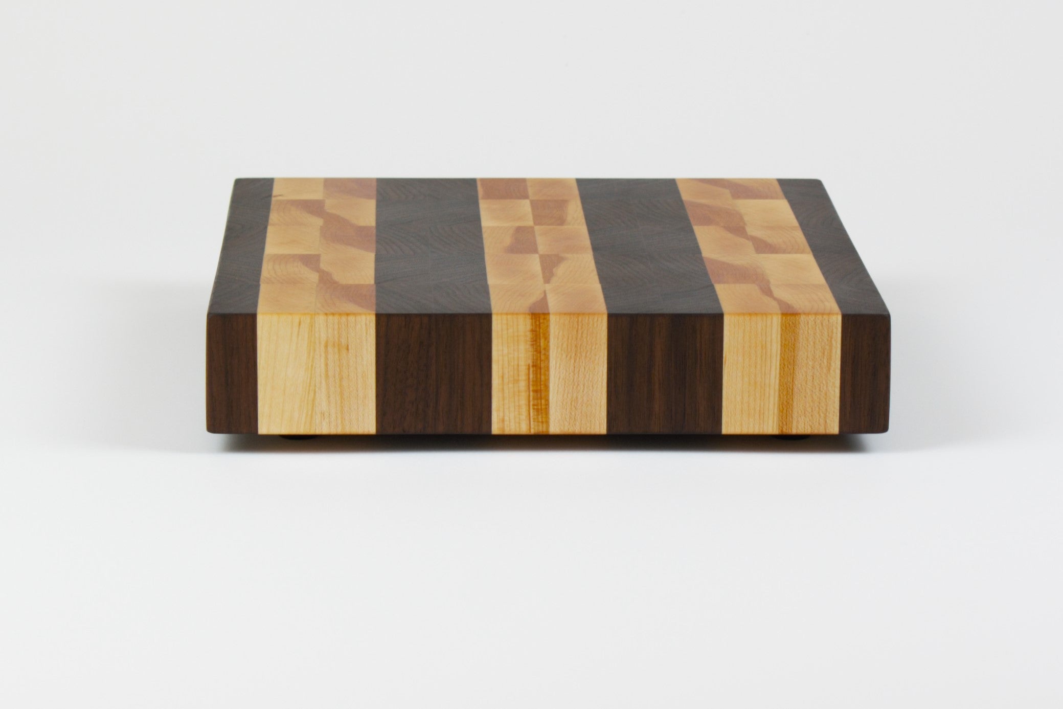 Luxurious Black Walnut and Maple cutting board, side view.