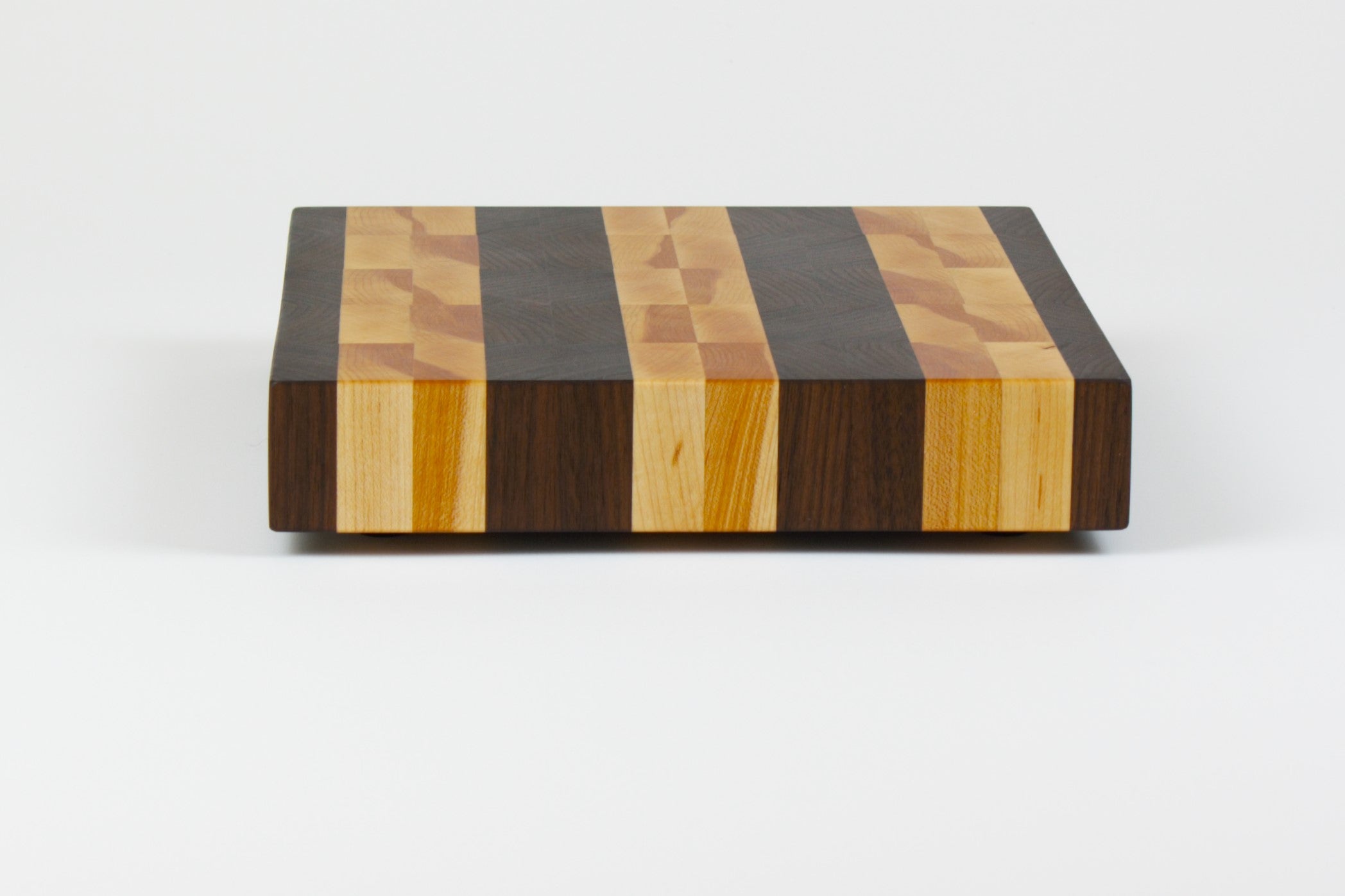 Luxurious Black Walnut and Maple cutting board, side view.