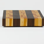 Luxurious Black Walnut and Maple cutting board, side view.