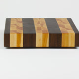 Luxurious Black Walnut and Maple cutting board, side view.