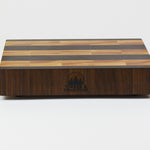 Luxurious Black Walnut and Maple cutting board, front view, displaying the Timber & Tradition logo.