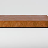 Cherry wood end grain cutting board with rich warm wood tones, rear view.