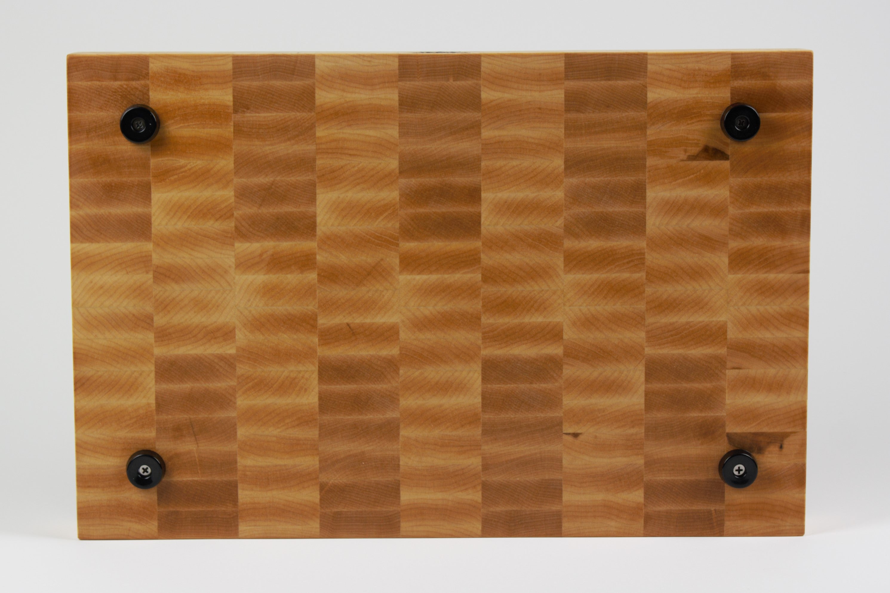 Classic Hard Maple cutting board with golden hues, straight on view of the bottom surface.  Four cutting board feet mounted to this surface.