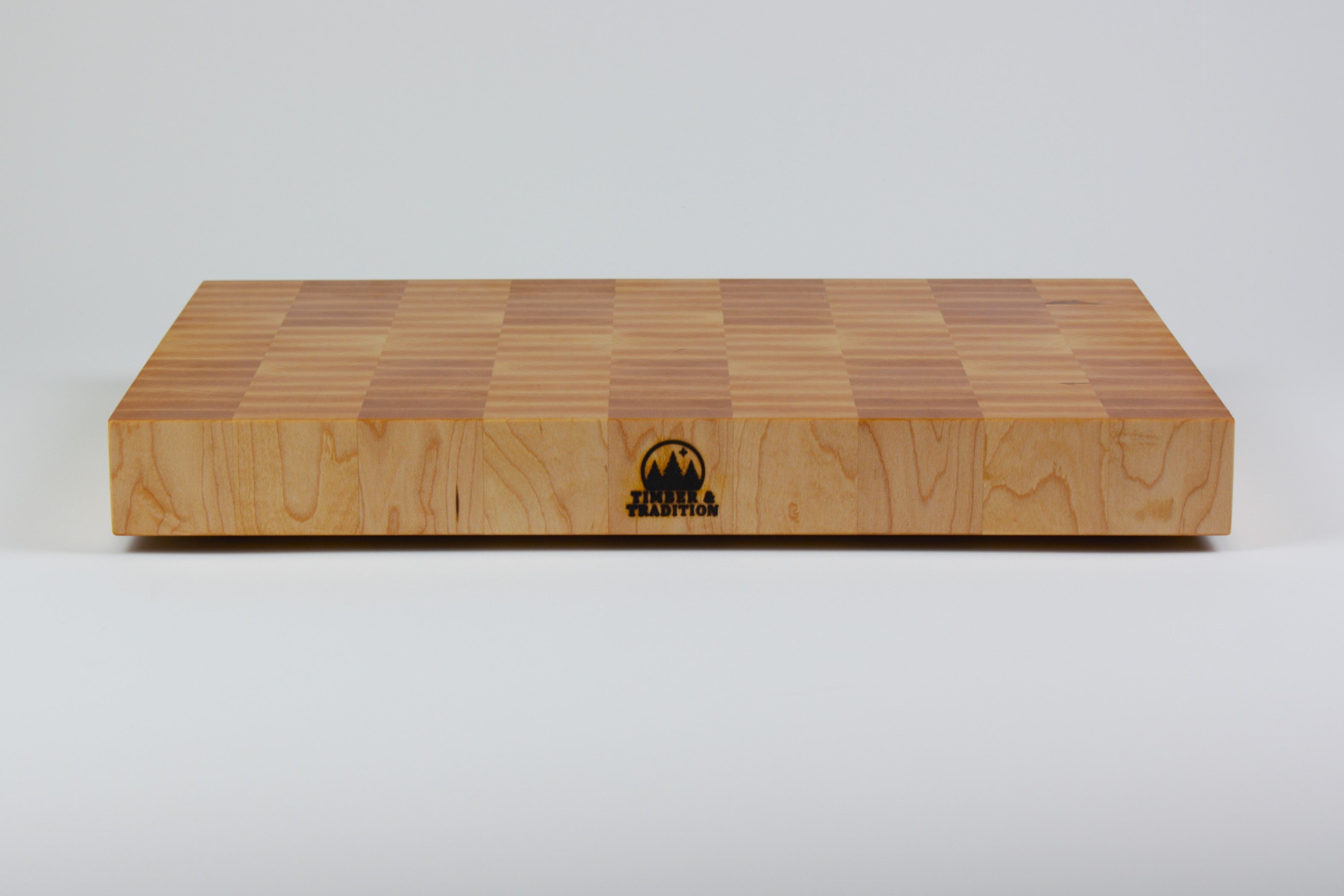 Classic Hard Maple cutting board with golden hues. The Timber & Tradition logo is burned into the center front, this is the front center view.