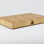 Classic Hard Maple cutting board with golden hues. The Timber & Tradition logo is burned into the center front, this is the front left corner view.