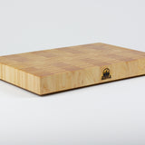 Classic Hard Maple cutting board with golden hues. The Timber & Tradition logo is burned into the center front, this is the front left corner view.