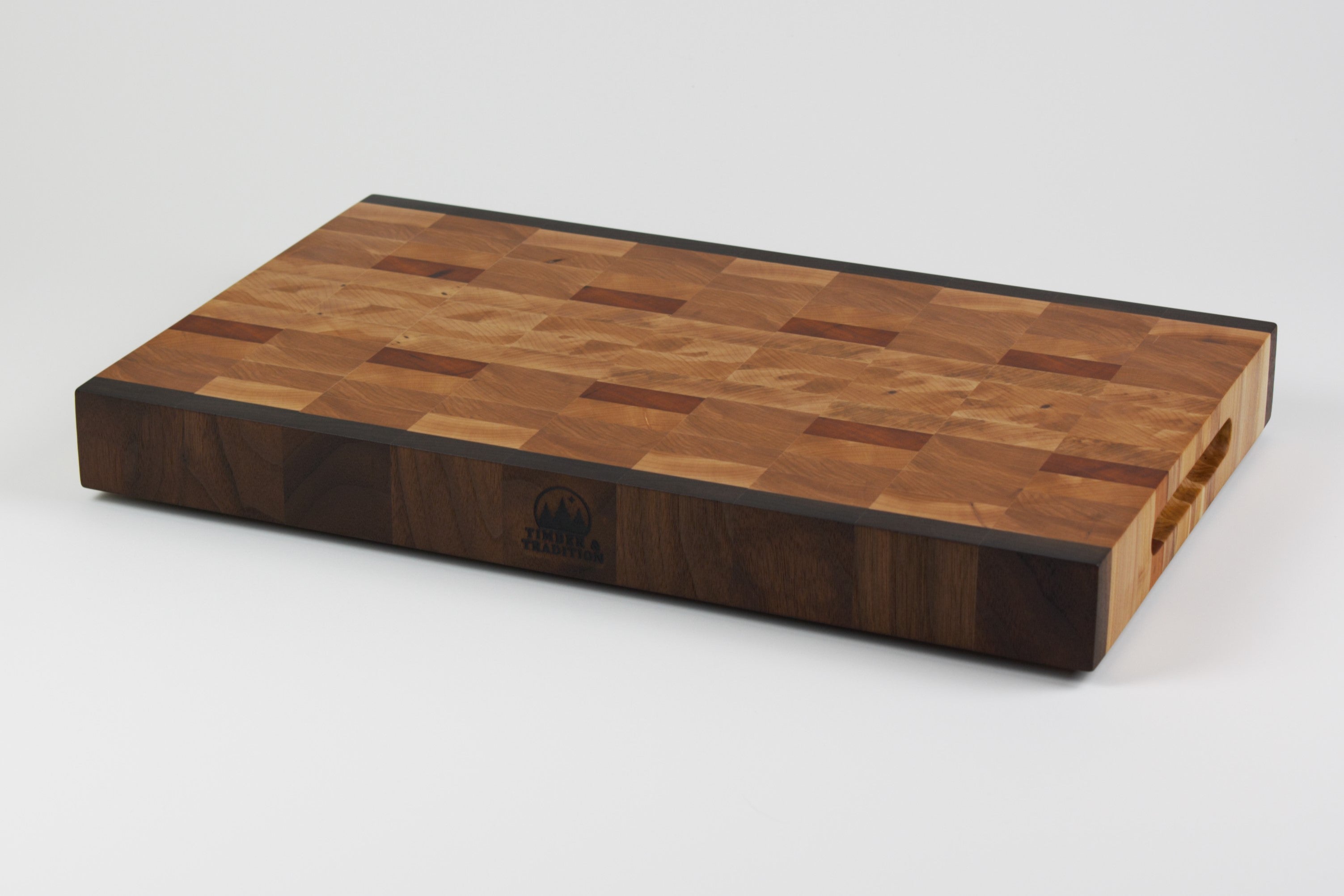 End grain cutting board made of rustic Hard Maple and accented with Tigerwood and Black Walnut. Front right corner view.